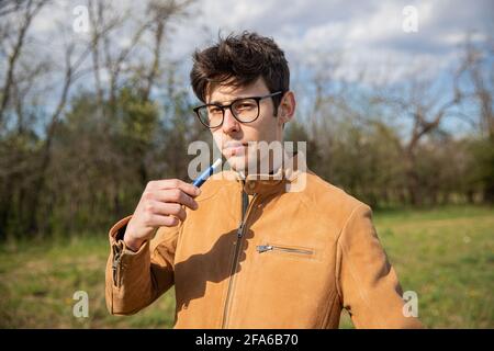 portrait of a young boy who smokes an electronic cigarette Stock Photo