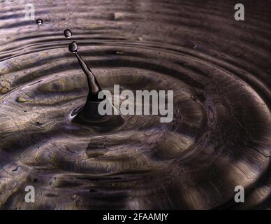 Water drop splash creating ripples Stock Photo