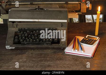 Vintage typewriter ,white  book, calculator ,pencil and candlelight on old wooden touch-up in still life concept Stock Photo