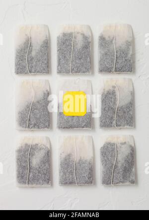 Black tea in teabags with yellow label on white background. Top view Stock Photo