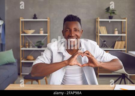 Male blogger recording video and showing heart gesture as a sign of love for his followers. Stock Photo