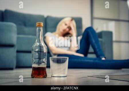 A Girl with a Bad Appearance Holds a Bottle of Alcohol Near Her Head. on a  Gray Background. Stock Image - Image of girl, excitement: 106671949