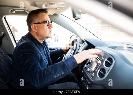 Middle age Man pressing red triangle car hazard warning button Stock Photo