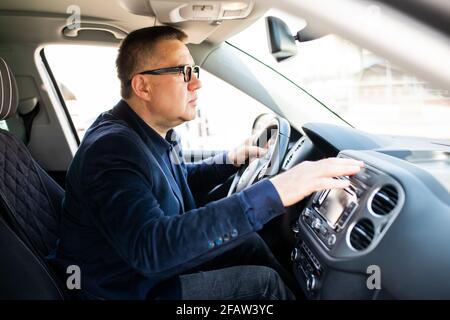 Middle age Man pressing red triangle car hazard warning button Stock Photo