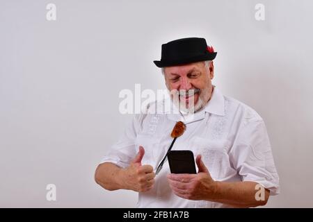 Cheerful old man is using his smartphone Stock Photo