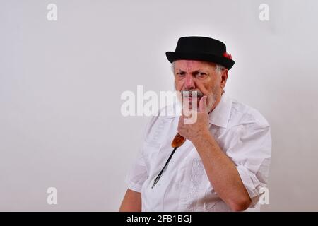 Suspicious old man holding his chin Stock Photo