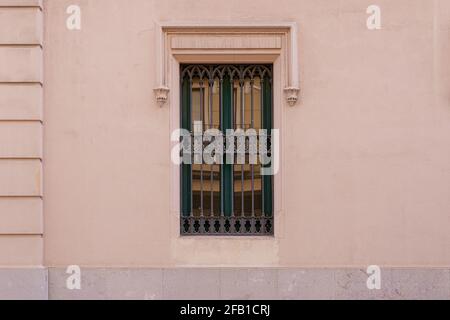 Vintage window with iron grating on a stone wall. Valencia, Spain Stock Photo