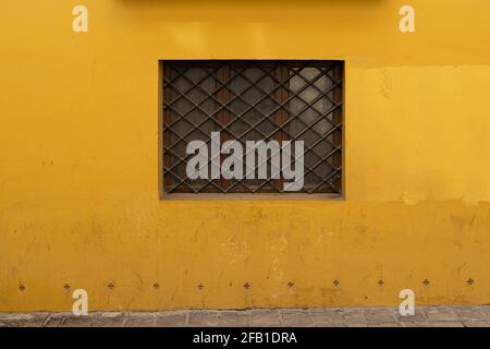 Vintage window with iron grating on a stone wall. Valencia, Spain Stock Photo