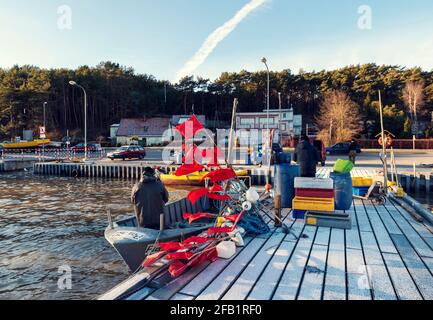 Fishermen at WorkPoland, Piaski, JAN 1st 2019: Fishermen at work on a harbor delivery fresh fish in a winter day Frozen pier, boat with fisherman and Stock Photo