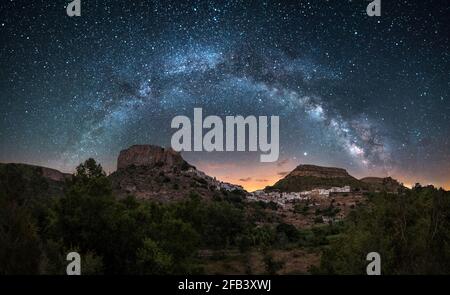 Night panoramic view of the Milky Way over a town in Spain, Chulilla Stock Photo