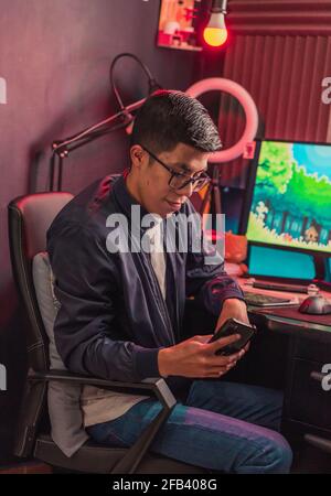 Young man texting with his cell phone to his friends. Stock Photo