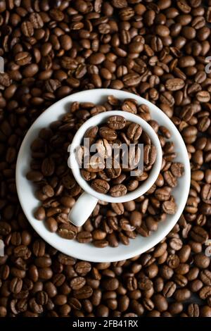 Cup with coffee beans on coffee beans background Stock Photo