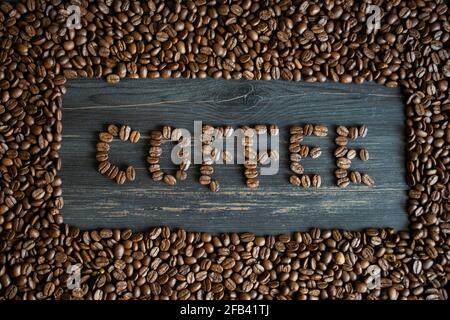 Coffee beans form a word on a coffee beans background Stock Photo