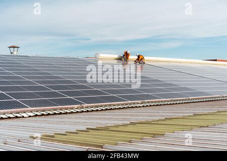 Unrecognizable solar panel technicians working a Spanish factory Stock Photo