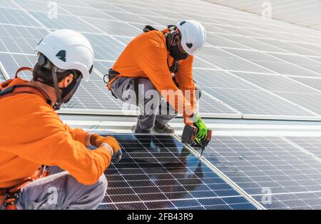 Unrecognizable solar panel technicians teamworking in Spanish factory Stock Photo