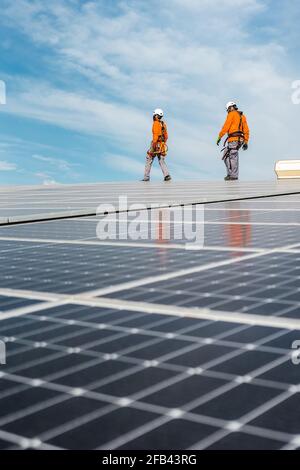 Unrecognizable solar panel technicians walking in Spanish installation Stock Photo