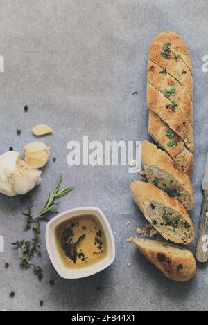 Flat lay of fresh baked homemade bread baguette ciabatta garlic and condiments Stock Photo