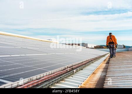 Unrecognizable solar panel technicians walking in Spanish installation Stock Photo