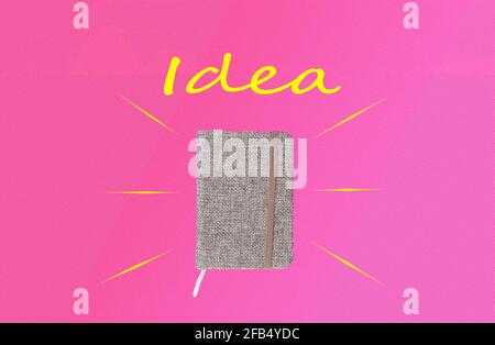 small memo notebook with gray cloth cover on pink background with "idea" lettering on top and copy space Stock Photo