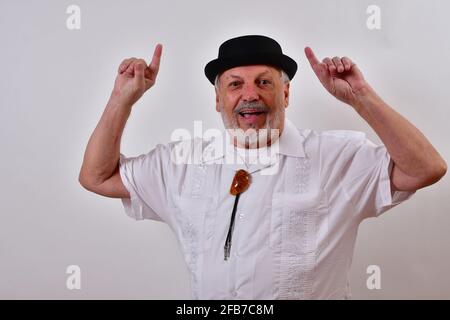 Happy elderly gentleman smiling and pointing up with both index fingers Stock Photo
