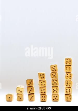 A row of dice standing on top of each other in a row on a white background Stock Photo