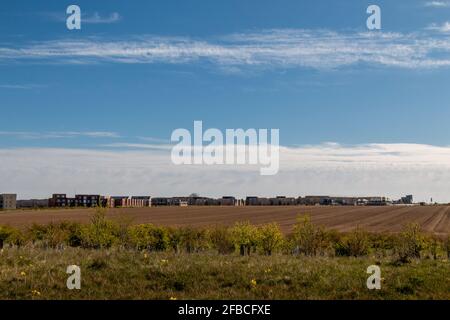 In the distance, across a tilled field, is the Trumpington Meadows housing development. Stock Photo