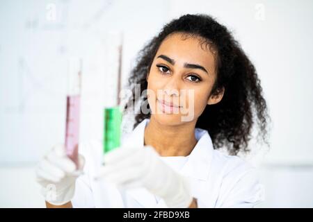 Young female researcher holding test tubes with liquid in laboratory Stock Photo