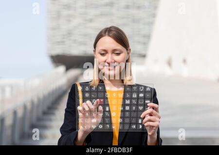 Smiling entrepreneur using futuristic digital tablet outdoors Stock Photo