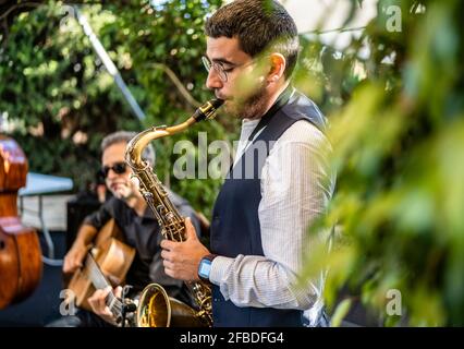 Man playing saxophone while performing at event Stock Photo