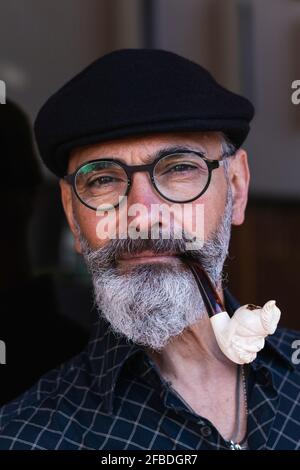 Bearded mature man smoking pipe Stock Photo