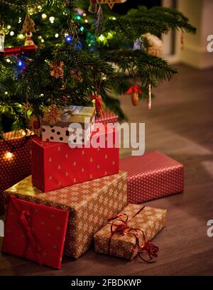 Wrapped gifts in front of Christmas tree at home Stock Photo