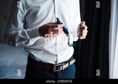 black pants holding in hands bow tie 