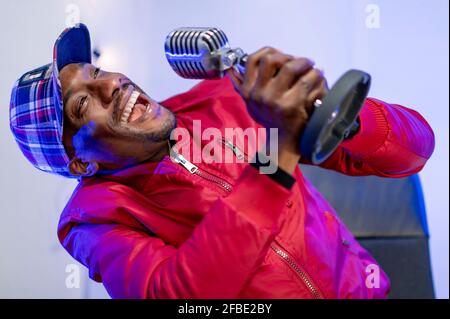 Cheerful male influencer enjoying during podcast in studio Stock Photo