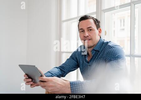 Male entrepreneur using digital tablet at workplace Stock Photo