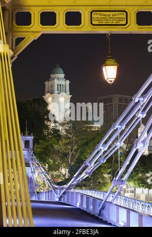 Singapore, Cavenagh Bridge at night with clock tower of Victoria Theatre and Concert Hall in background Stock Photo