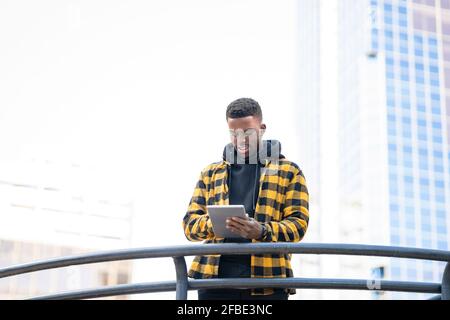 Young man using digital tablet at railing Stock Photo