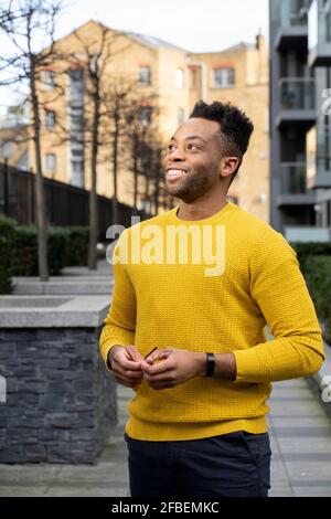 Smiling young man contemplating while looking away Stock Photo