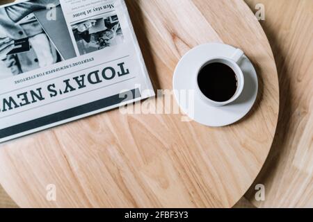 Black coffee with newspaper on wooden table Stock Photo