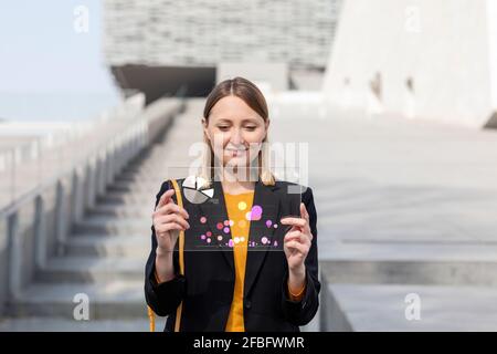 Female entrepreneur working over glass digital tablet outdoors Stock Photo