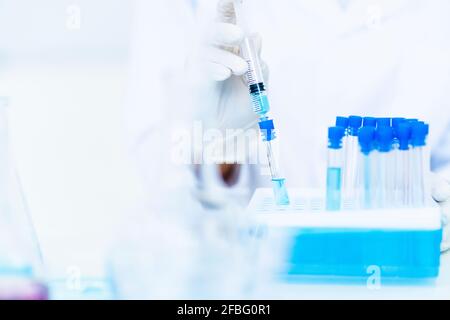 Researcher injecting liquid in test tube at laboratory Stock Photo