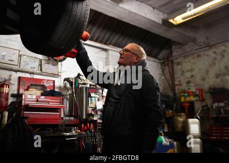 Senior repairman examining tire in industry Stock Photo