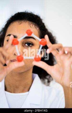 Female researcher looking through molecular structure in laboratory Stock Photo