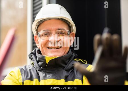 Smiling male engineer gesturing while working Stock Photo