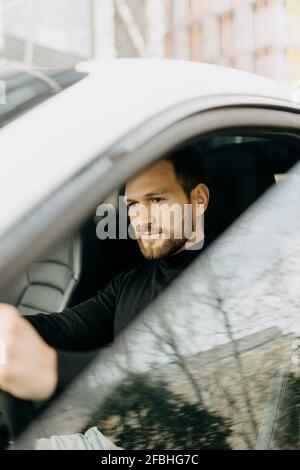 Handsome young man driving electric car Stock Photo
