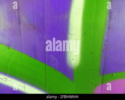Purple, green, pink, white and yellow sprayed on a concrete wall Stock Photo