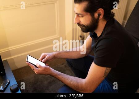 Young man using smart phone at home Stock Photo