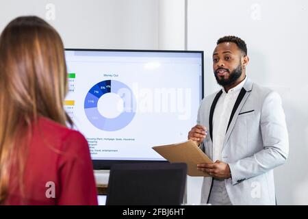 Young male entrepreneur planning business plan with colleague in office Stock Photo