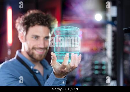 Male IT professional holding hologram of database in server room Stock Photo