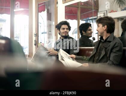 Two men talking in barber shop while waiting for haircut Stock Photo