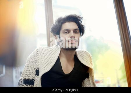 Portrait of young handsome man wearing cardigan Stock Photo